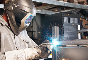 Facharbeiter beim präzisen Schweißen von hochwertigen Metallkonstruktionen in einer Werkstatt – Qualität und Handwerkskunst bei der Herstellung erstklassiger Produkte.