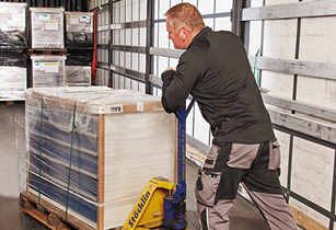 Facharbeiter beim Verladen von Waren mit einem Hubwagen für schnelle und zuverlässige Lieferung – Effiziente Logistik und termingerechte Versandabwicklung.