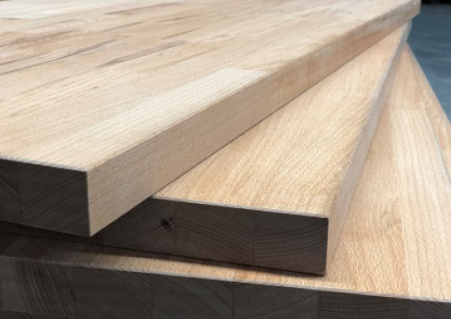 Stapel von massiven Buchenholzplatten mit sichtbarer Maserung und Kanten.