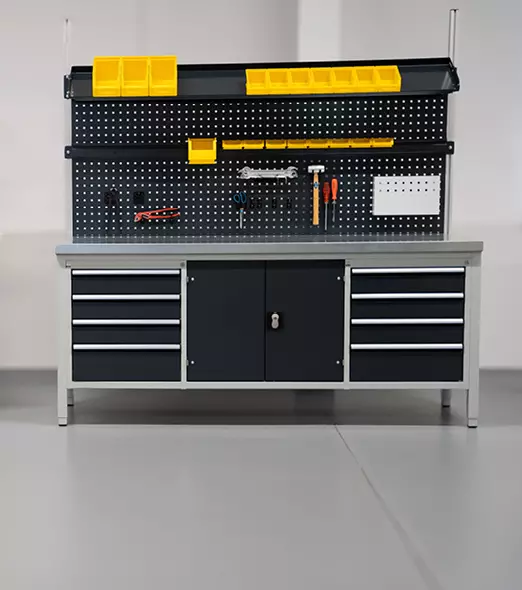 Voll ausgestattete Werkbank mit Systemaufbau, Lochwand für Werkzeuge und mehreren Schubladen und Schrankfächern.